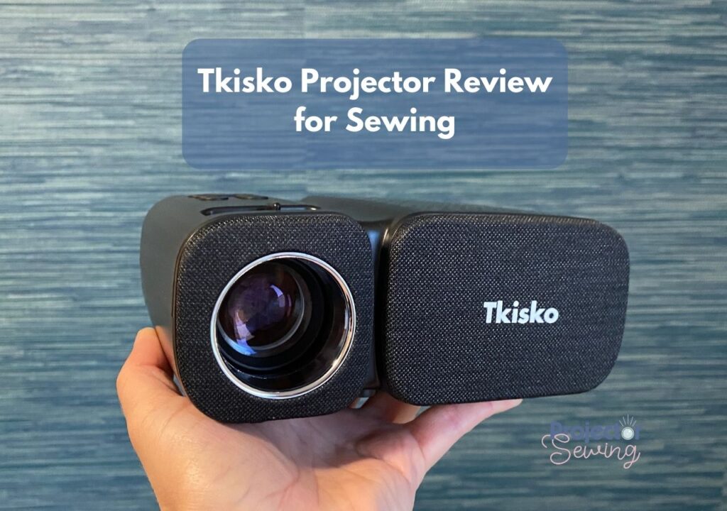 Tkisko projector sitting in the palm of hand.